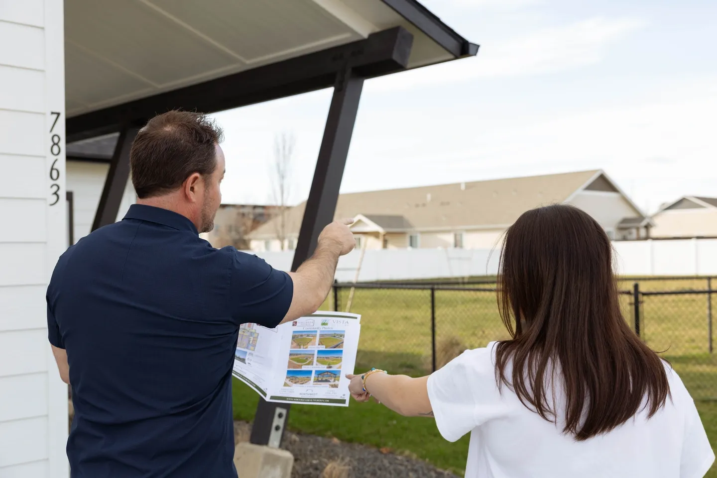 People reviewing construction plans outside a house.